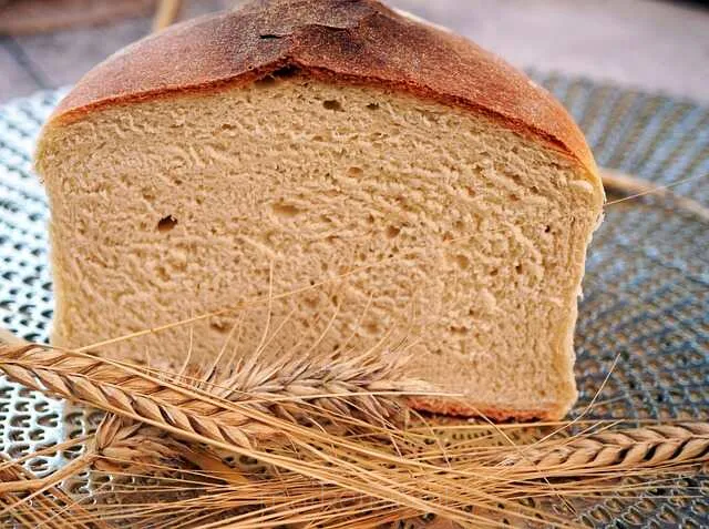 Chleb w kształcie bochenka na drewnianym tle - tradycyjne pieczywo