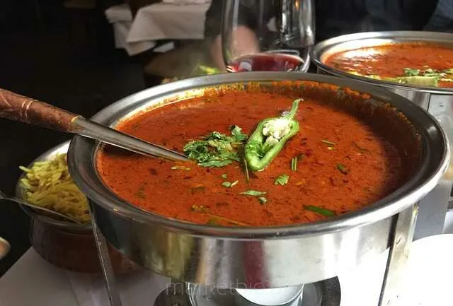 Talerz curry z warzywami, przyprawami i ryżem na drewnianym stole